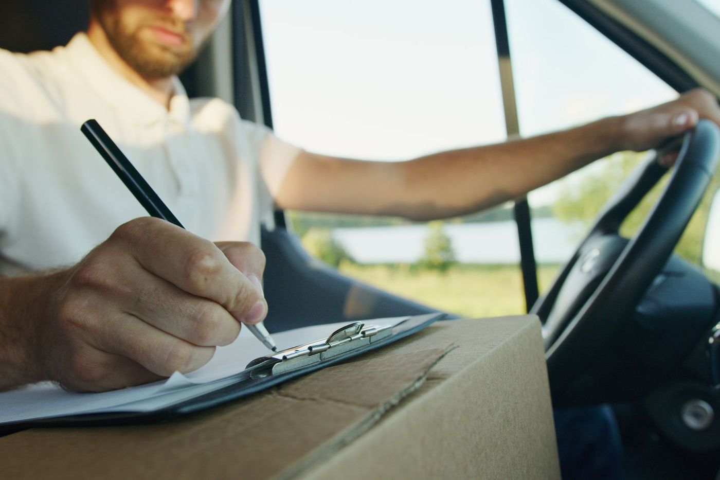 A driver going through export paperwork in the cab of the van before setting off